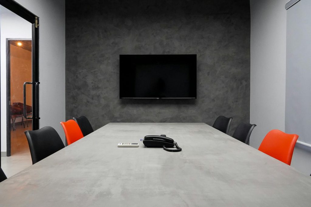Expert movers install a TV on the wall of a modern office.