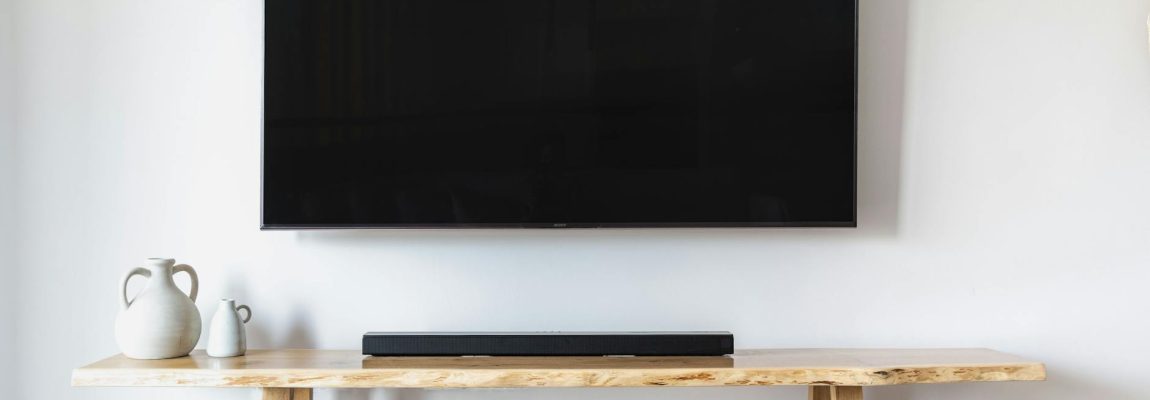 Two movers installing a TV wall mount in a living room near Nairobi, Kenya.