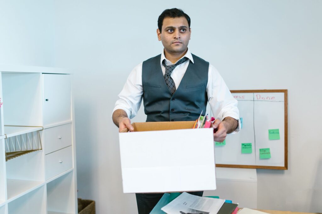 Moving boxes and furniture into a moving truck for office relocation.