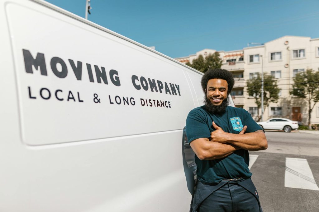 A team of movers loads furniture onto a truck in a residential area.