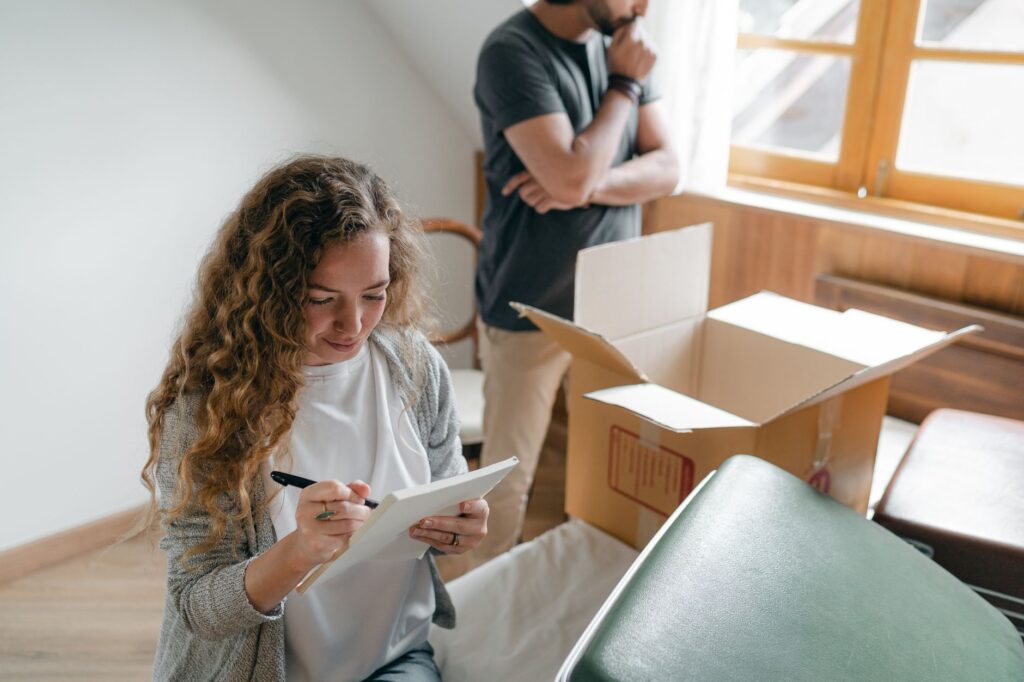 A moving truck is loaded next to a house with a checklist overlay for relocation preparation.