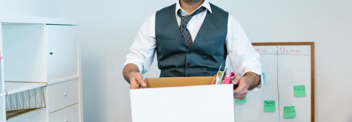 Professional movers packing office boxes in a modern workspace.