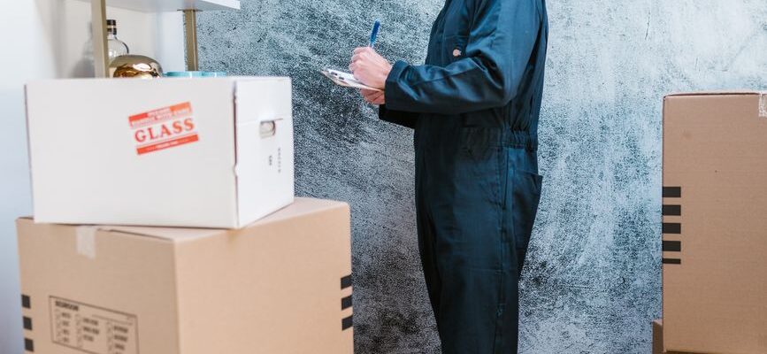 Two men loading furniture into a moving truck for a house or office relocation.