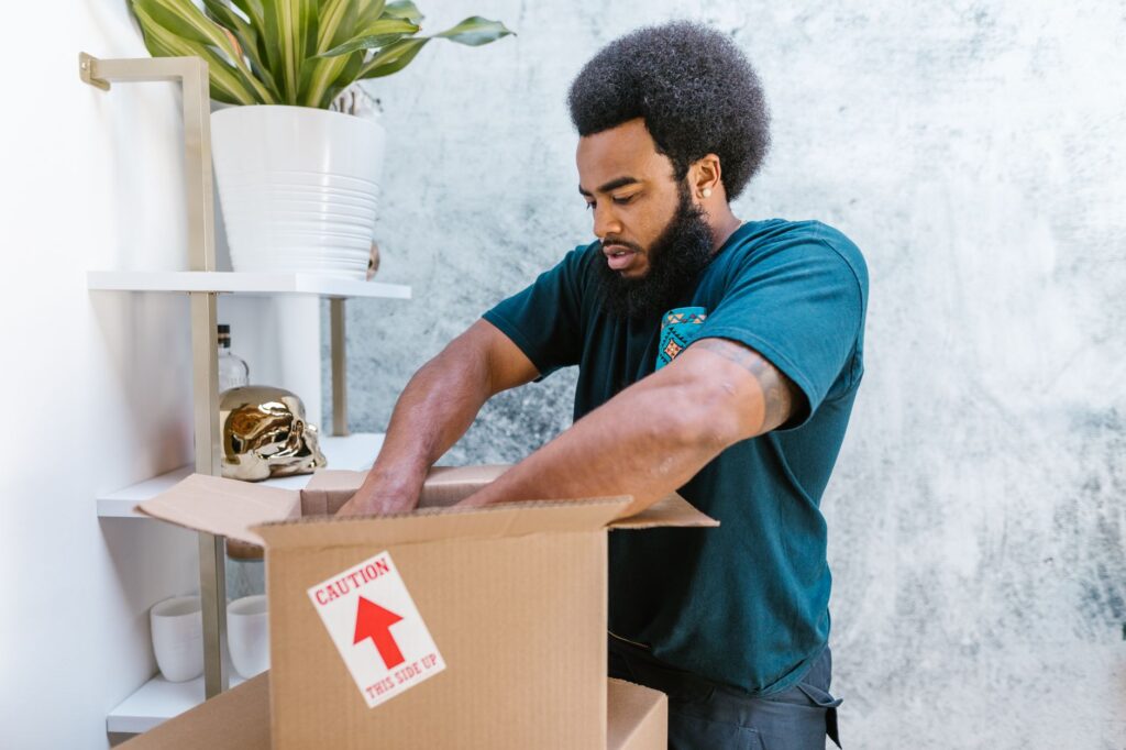 A moving truck is being loaded with boxes and furniture through a large back door.