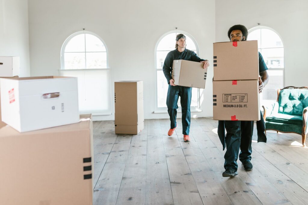 Syokimau apartment movers - Two movers carrying a sofa into an apartment in Syokimau, Kenya.