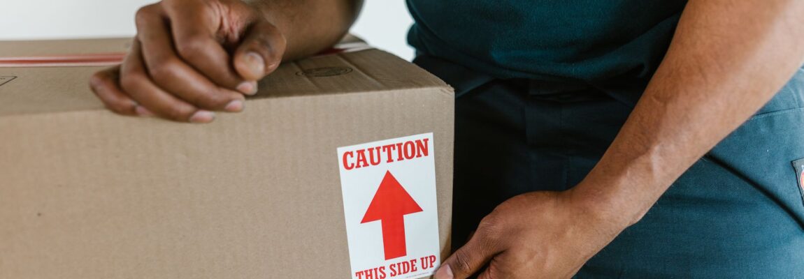 Two movers carrying a large box into a moving truck in Kilimani.